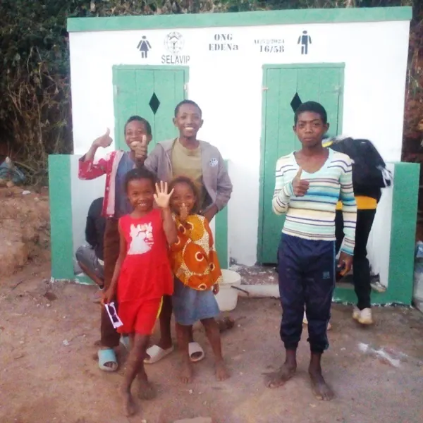 Des enfants devant une latrine communautaire fraîchement construite