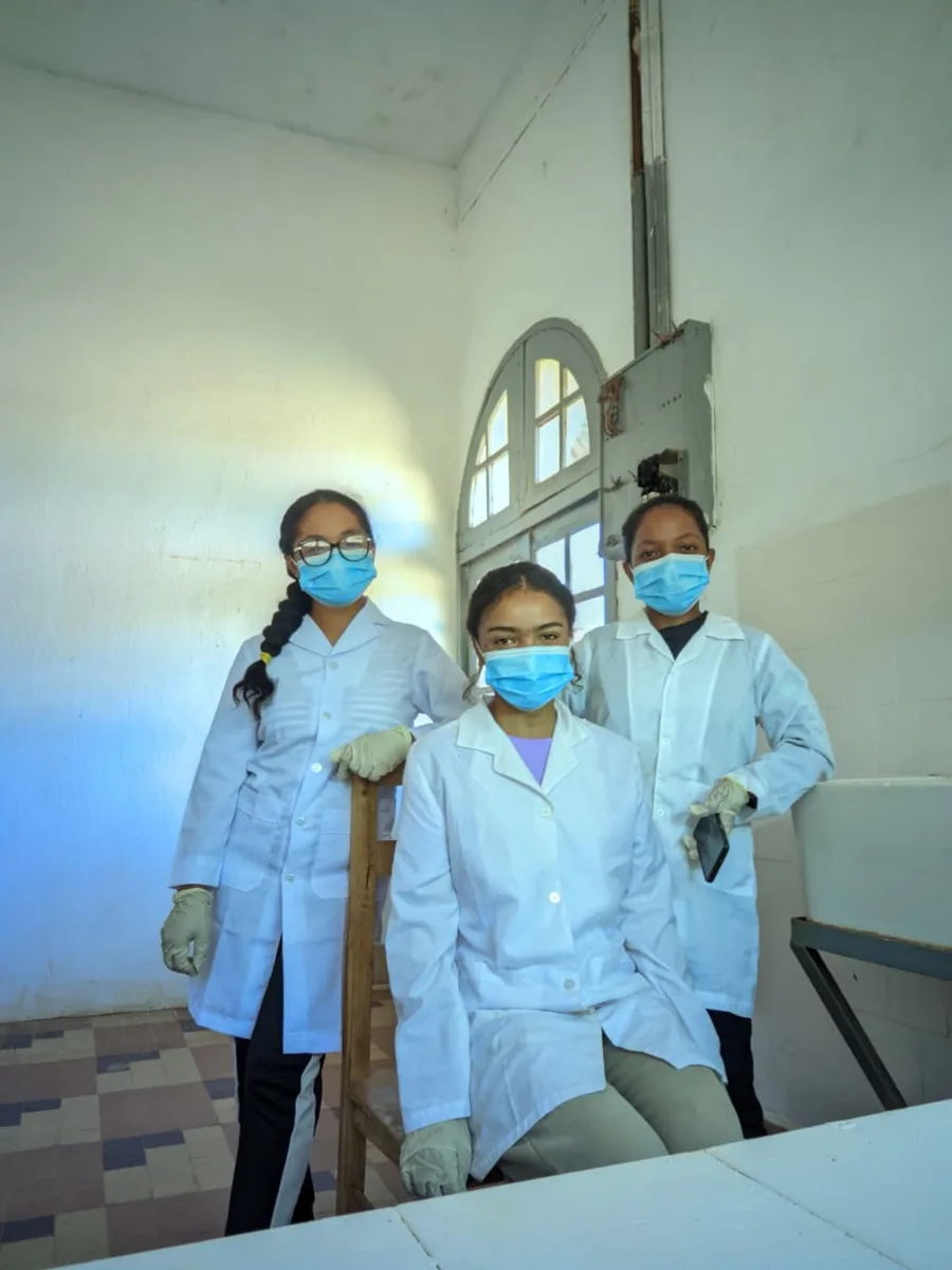Trois étudiantes en blouse blanche dans leur laboratoire